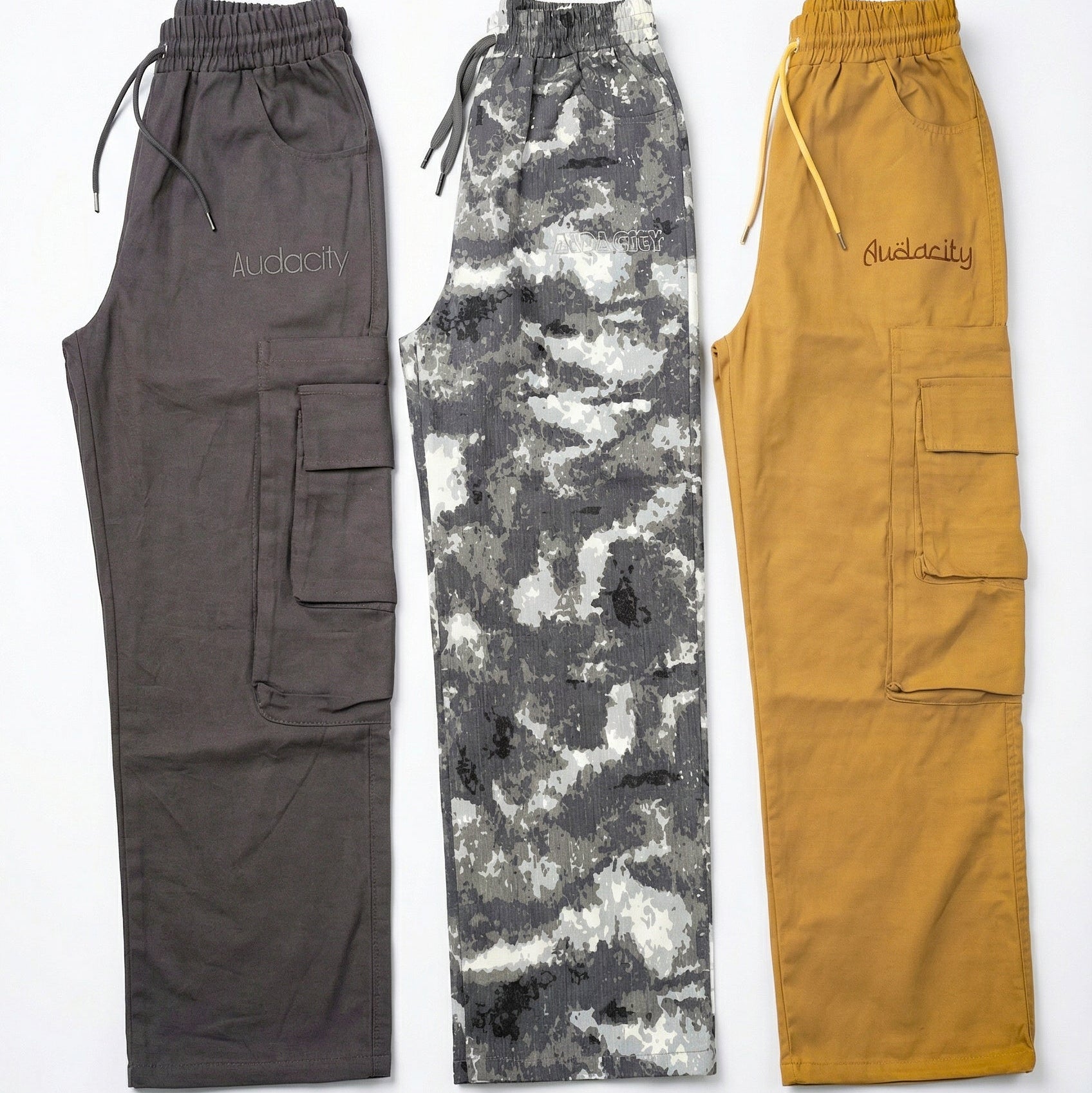 Pairs of cargo pants in gray, camouflage, and mustard yellow on a white background.